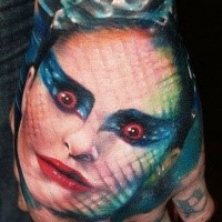 Colored horror style creepy woman face tattoo on hand