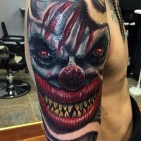 Colored horror style large creepy clown demon face tattoo on shoulder