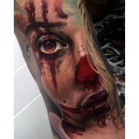 Colored horror style realistic looking bloody woman face tattoo on hand