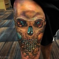 Colored illustrative style thigh tattoo of skull