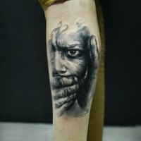 Colored leg tattoo of terrifying human face