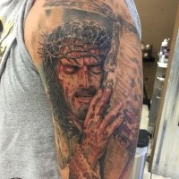Colored shoulder tattoo of dramatic Jesus with cross