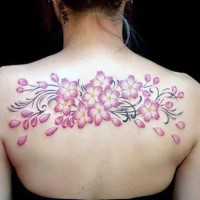 Colored upper back tattoo of pink flowers