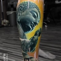 Colored very detailed Buddha statue tattoo on leg