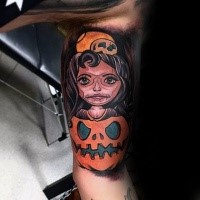 Colorful biceps tattoo of woman inside pumpkin
