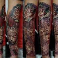 Colorful big forearm tattoo of various tribes people portraits and rose