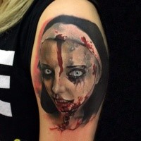 Colorful creepy looking shoulder tattoo of bloody woman