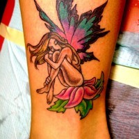 colorato fata seduta sul fiore tatuaggio sulla gamba