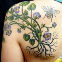 Colorful flower with roots and bee tattoo on shoulder blade