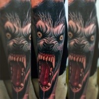 Colorful forearm tattoo of large werewolf face