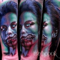 Colorful large creepy looking forearm tattoo of monster woman face