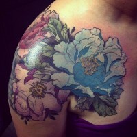 Tatuaje en el hombro, tres flores grandes pintorescas