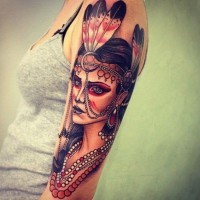 Tatuaje en el brazo,
mujer hermosa con plumas en el  pelo y collares