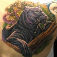 Tatuaje en la espalda en color  de una pantera descansando encima de un árbol.