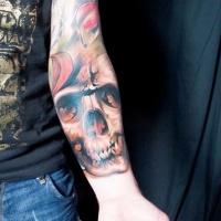 Colorful skull with falling leaves forearm tattoo