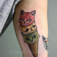 Tatuaje en el brazo,
gatos en forma de helado de varios colores