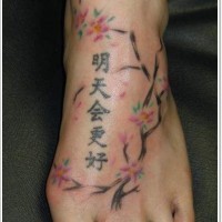 Tatuaje en el pie, jeroglíficos elegantes y ramita bonita suave