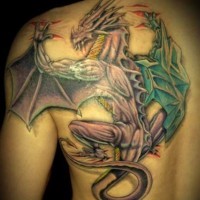 Coloured dragon tearing skin tattoo on shoulder blade