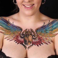 Tatuaje en el pecho de un escarabajo egipcio coloreado con alas.