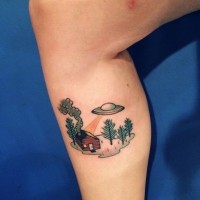 Coloured flying ufo over house tattoo on leg