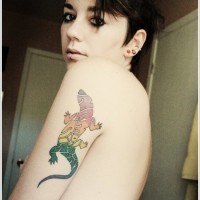 Tatuaje  de lagarto multicolor en el brazo