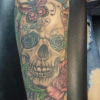 Tatuaje en el antebrazo, cráneo con rosas  en lugar de ojos