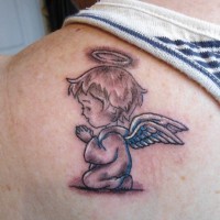 Farbiger kleiner Engel Tattoo am Schulterblatt