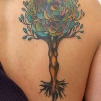 Tatuaje en el omóplato de un árbol coloreado.