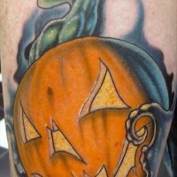 Comic books style colored Halloween pumpkin tattoo on leg
