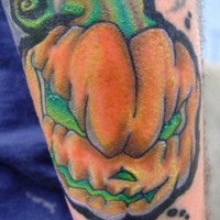 Comic books style multicolored little pumpkin on arm tattoo