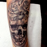 fresco 3D dettagliato di ferro grande cranio con fiore tatuaggio su braccio