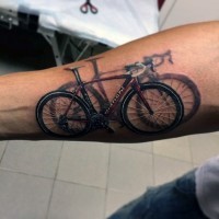 Tatuaje en el antebrazo,
bicicleta de montaña con sombra