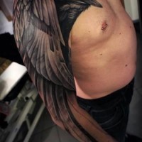 Tatuaje en el brazo, cuervo negro muy realista