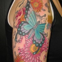 Tatuaje en el brazo, mariposa grande preciosa entre flores bonitas