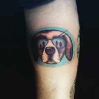 Cool cartoon like colored dog in sun glasses tattoo on arm