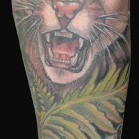 Tatuaje en el antebrazo,
gato salvaje enfadado en la selva