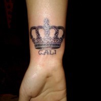 bella corona e scrittura tatuaggio su polso