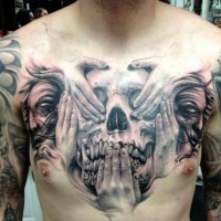 Tatuaje en el pecho,  cráneo con manos y caras de hombres