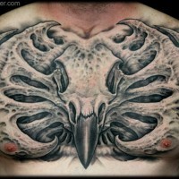 Cool looking colored bird skull tattoo on chest with alien like bones