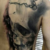 Tatuaje en la espalda,
cráneo con reloj borroso