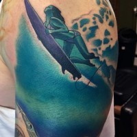 Tatuaje en el hombro,
surfista hermosa en el agua y tiburón