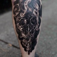 fresco stilizzato nero e bianco cranio in fumo  tatuaggio su gamba