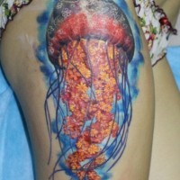 Tatuaje en el muslo,  medusa brillante  grande en el agua