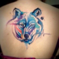 Cool wolf's head with colored paint drips tattoo on lady's back in watercolor style with heart rhythm