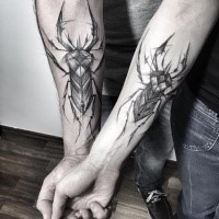 Couple style black ink identical forearm tattoo of big bugs by Inez Janiak