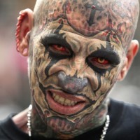 Wahnsinniges Tattoo auf männlichem Gesicht