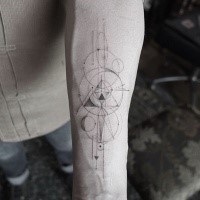 Figuras geométricas de tinta negra creativa con círculos tatuados en el antebrazo