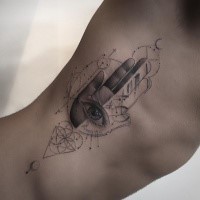 Tatuaggio di lato Hamsa con inchiostro nero dal design creativo con simboli mistici