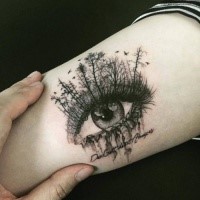 Creative painted beautiful looking tattoo of woman eye with trees and lettering