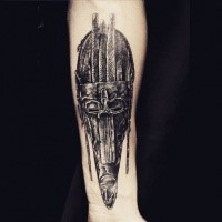 Creepy and mystical looking arm tattoo of ancient tribal mask